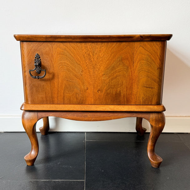 Mid-century wooden cabinet or night stand with single door and curved legs, vintage furniture piece.