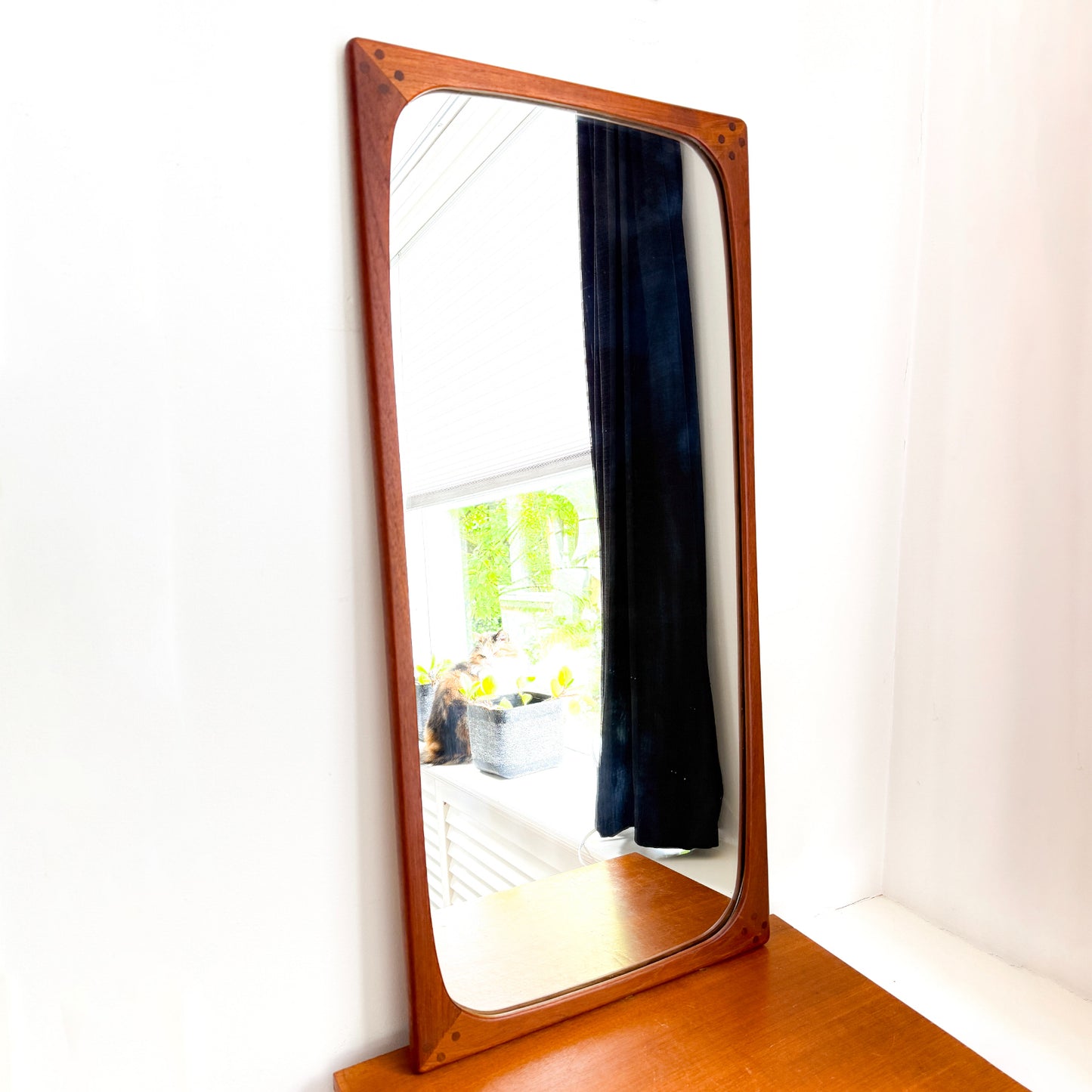 Scandinavian modern teak wall mirror with rounded corners and contrasting wood details, mid-century style.