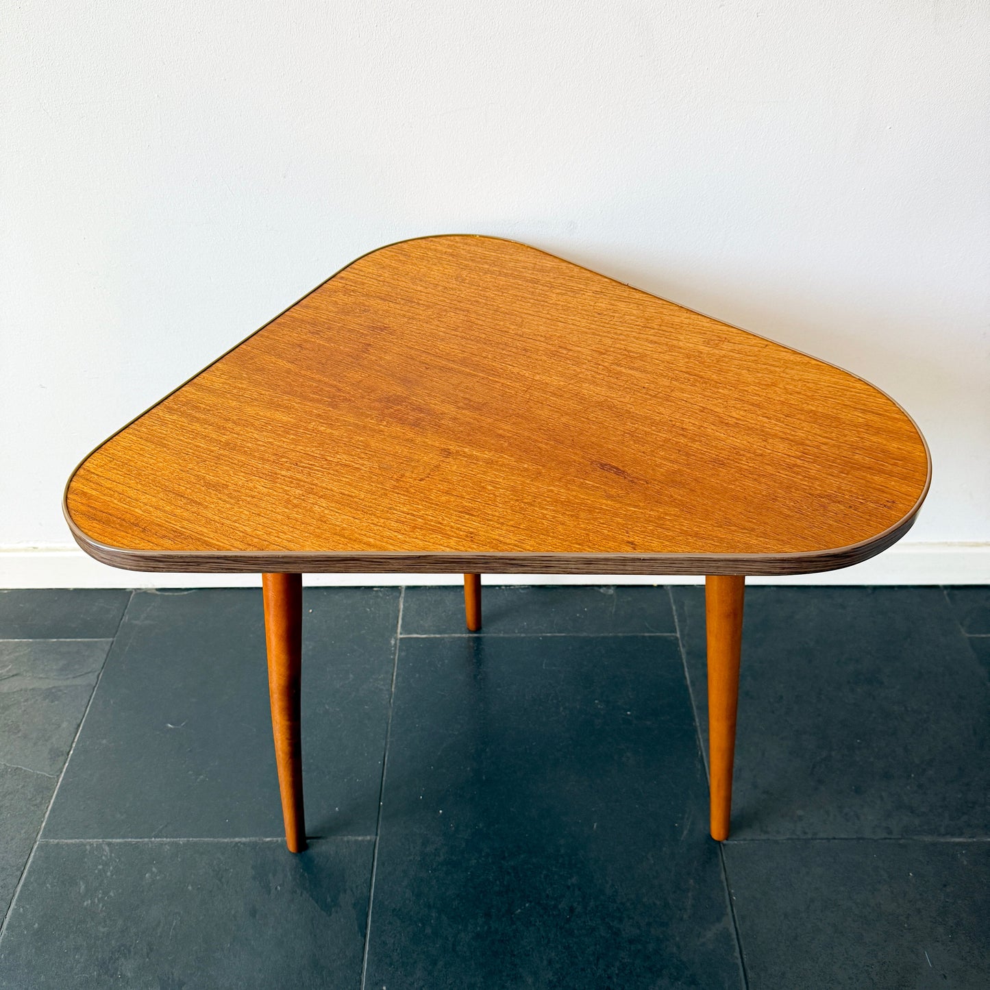 Mid-century modern asymmetrical side table, wood with Formica edge.