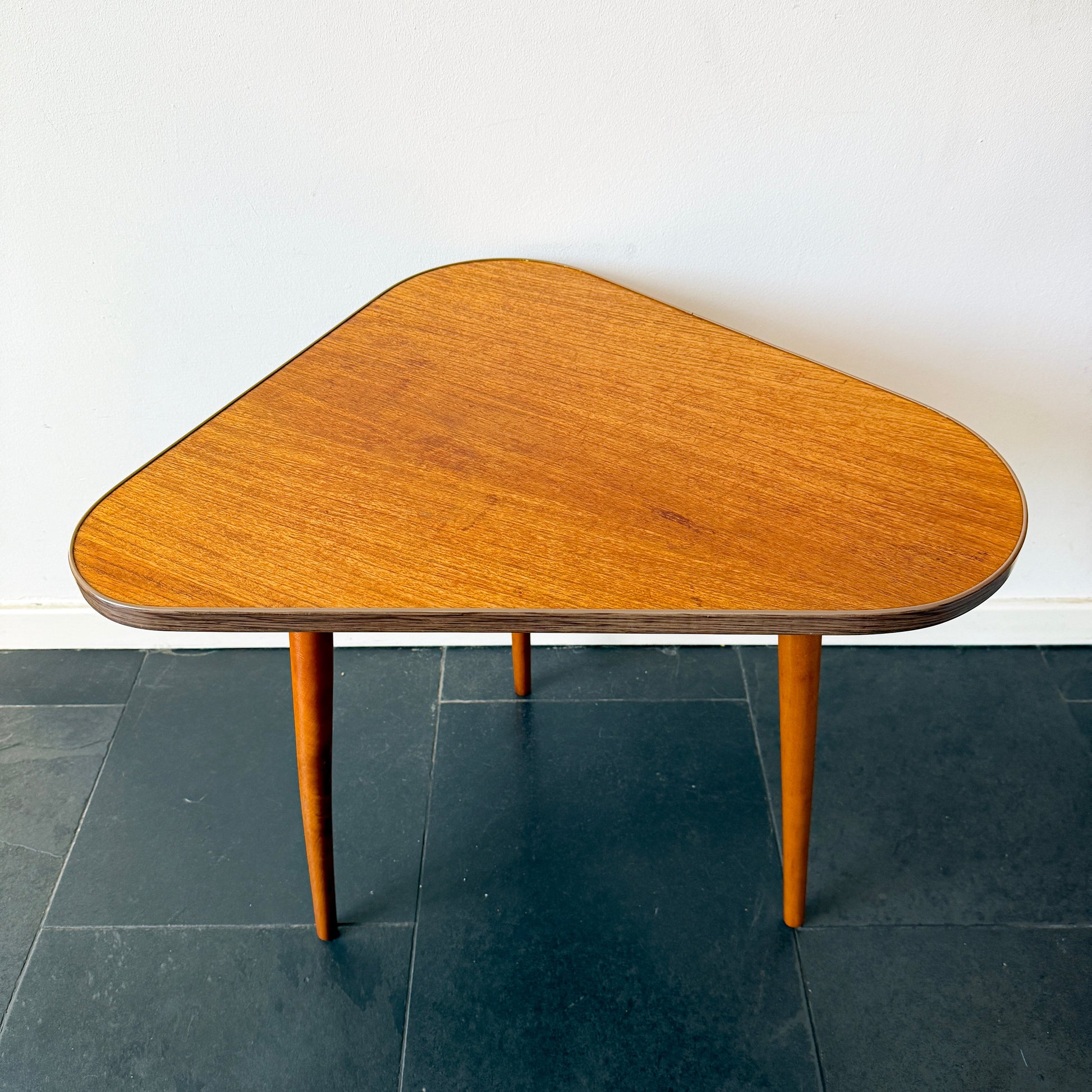 Mid-century modern asymmetrical side table, wood with Formica edge.