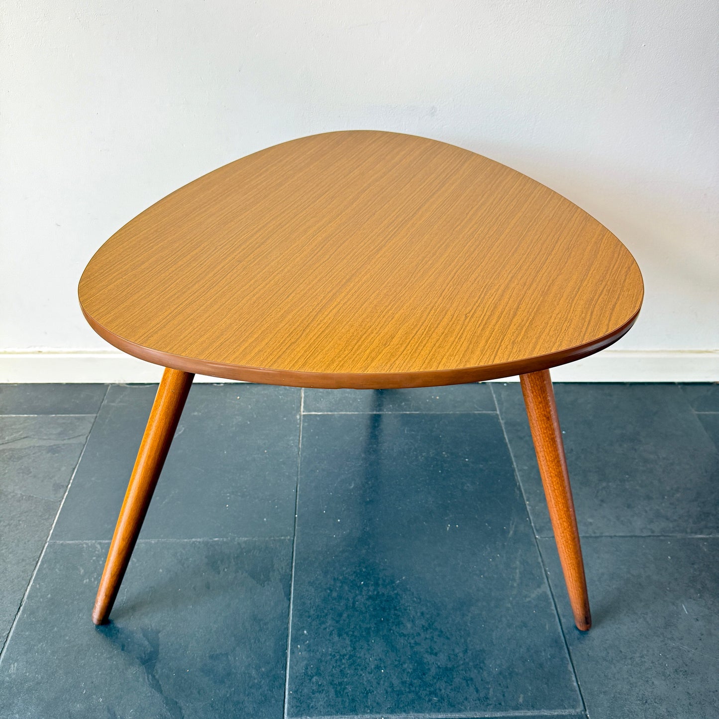 Mid-century modern triangular coffee table, Formica top and wooden legs.