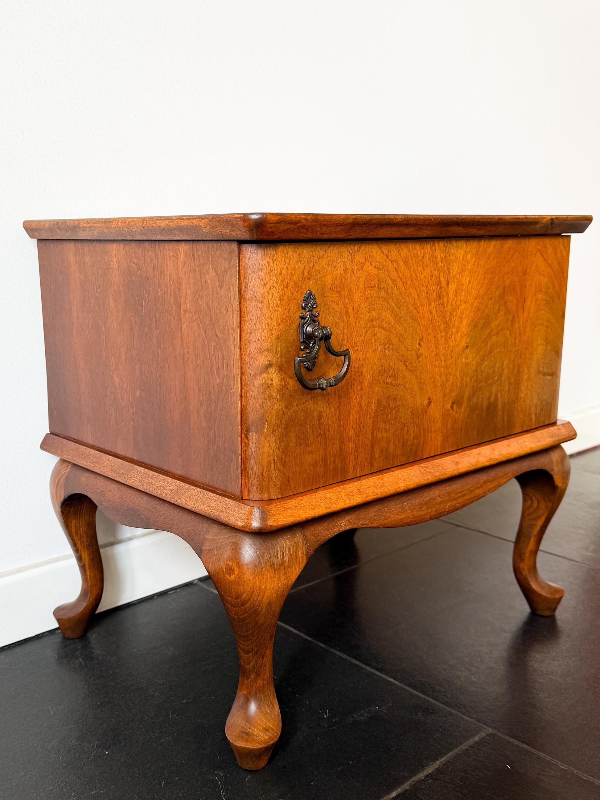 Mid-century wooden cabinet or night stand with single door and curved legs, vintage furniture piece.