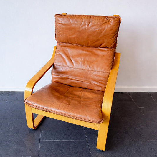 Scandinavian vintage IKEA Poäng armchair in bentwood with cognac leather upholstery, design introduced in 1976. By Vintagefindsbyrenata.