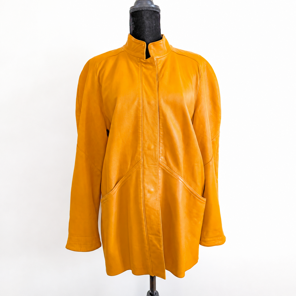 1980s-inspired vintage ochre yellow genuine leather jacket by Marina, with stand-up collar, concealed snap-button closure and curved front pockets.
