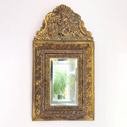 Victorian wall cabinet with beveled mirror, wood and brass-toned embossed metal, likely late 19th to early 20th Century. By Vintagefindsbyrenata