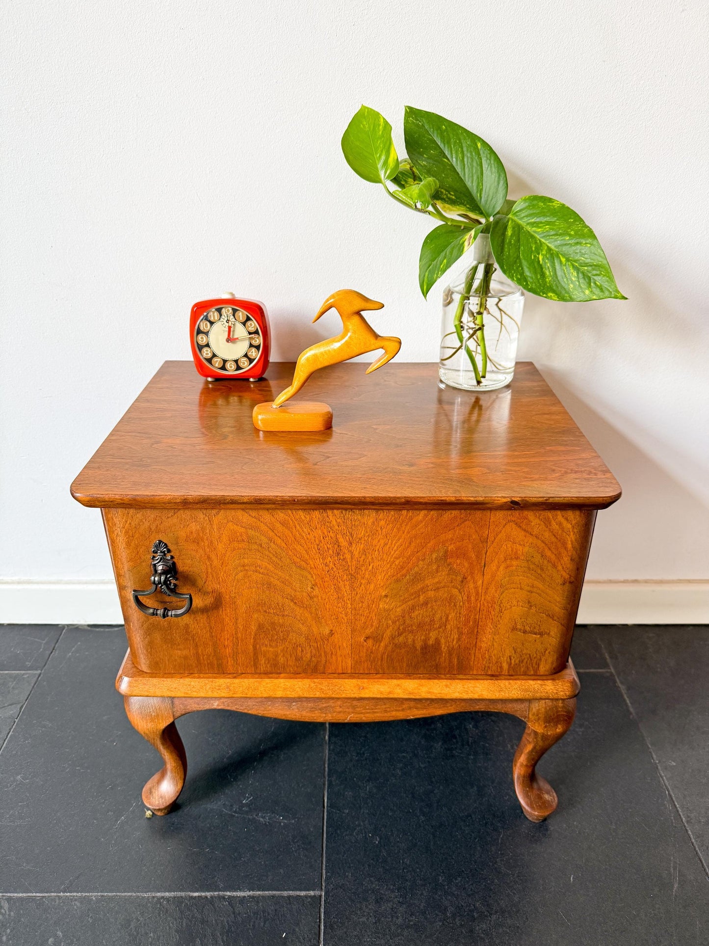 Mid-century wooden cabinet or night stand with single door and curved legs, vintage furniture piece.