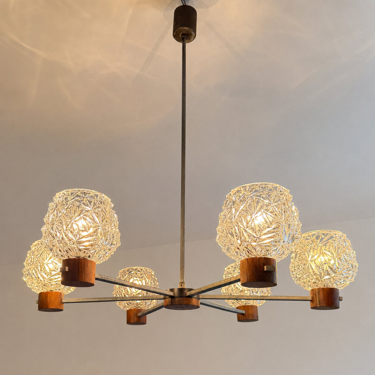 Mid-Century Modern six-arm chandelier with pressed glass shades, metal frame and wood veneer details. vintagefindsbyrenata